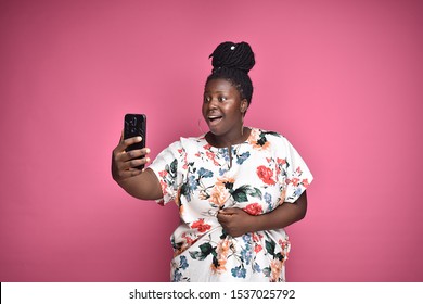 Cute Plus Size African Lady Looking At Her Phone She Is Holding With Excitement And Suprise