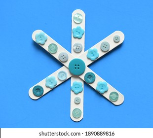 Cute Popsicle Stick Snowflake Craft For Kids Winter Art Project With Buttons Isolated On Blue Background Fun Activity For Children Indoor Easy Simple Inexpensive Creative Ideas Cheap Crafts Mom Blog