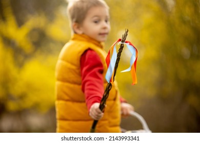 Cute preschool child, boy, holding handmade braided whip made from pussy willow, traditional symbol of Czech Easter used for whipping girls and women to receive eggs and sweets