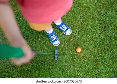 Cute Preschool Girl Playing Mini Golf With Family. Happy Toddler Child Having Fun With Outdoor Activity. Summer Sport For Children And Adults, Outdoors. Family Vacations Or Resort.