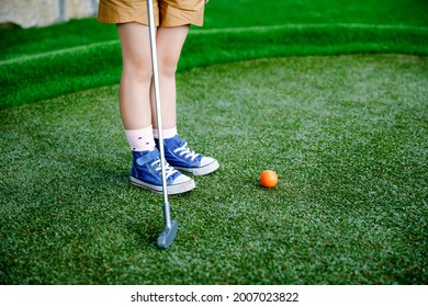 Cute Preschool Girl Playing Mini Golf With Family. Happy Toddler Child Having Fun With Outdoor Activity. Summer Sport For Children And Adults, Outdoors. Family Vacations Or Resort.