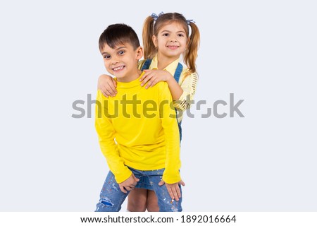 Cute preschool kids smiling and posing in casual clothes against white background with side space.