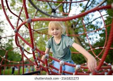 Cute preschooler boy having fun on outdoor playground. Spring summer autumn active sport leisure for child. Activity for family with children. Equipment of entertainment park for kids. - Powered by Shutterstock