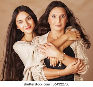cute pretty teen daughter with mature mother hugging, fashion style brunette makeup close up, warm colors