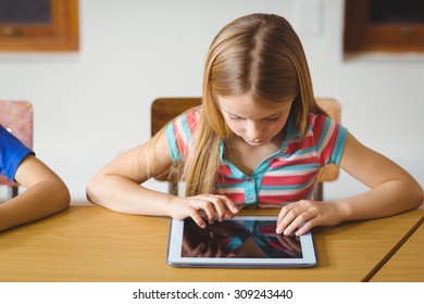 Cute pupil in class using tablet pc at the elementary school
