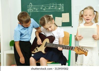 Cute Pupils Having Music Lesson In Classroom At Elementary School