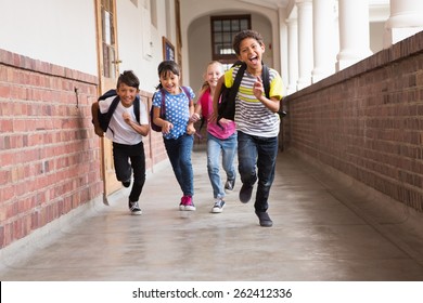 Cute Pupils Running Down The Hall At The Elementary School