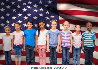 Cute Pupils Smiling At Camera In Classroom Against Digitally Generated American National Flag