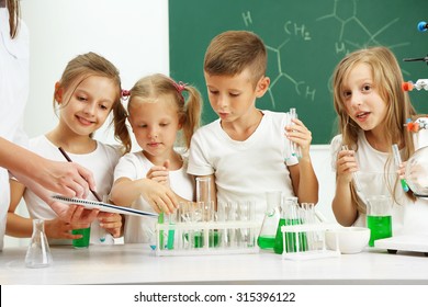 Cute pupils with teacher doing biochemistry research in chemistry class - Powered by Shutterstock