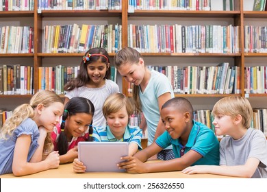 Cute Pupils Using Tablet Computer In Library At The Elementary School