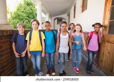 Cute Pupils Walking Down The Hall At The Elementary School