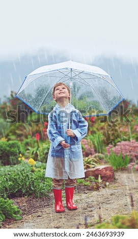 Cute, raincoat and rain for umbrella, child and outdoor with smile for winter, sky and safety footwear. Happiness, shoes and adorable kid in street, water and youth in weather of Austin and USA
