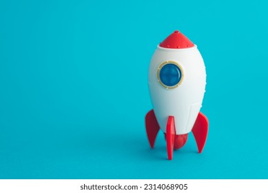 Cute rocket toy is launching on blue background copy space. Abstract business startup, innovation, development, business fast growth to successful goal target, space technology concept. - Powered by Shutterstock