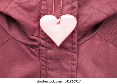 Cute Rose Safety Reflector In The Form Of Heart On The Winter Jacket. Necessary Equipment To Pedestrians For Walks During Dark Conditions.