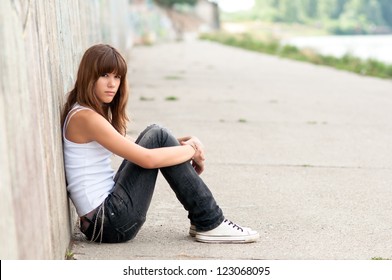 Cute Sad Teenage Girl Sitting Alone In Urban Environment.