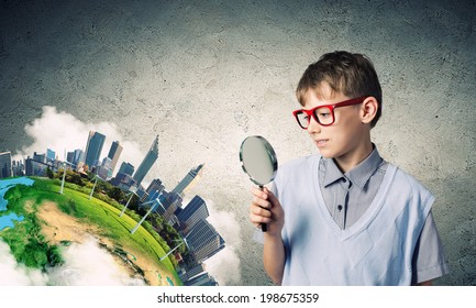 Cute school boy examining objects with magnifying glass. Elements of this image are furnished by NASA - Powered by Shutterstock