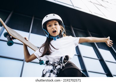 Cute School Girl Skating On Skate Board In The City Wearing Safety Helmet