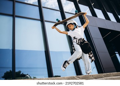 Cute School Girl Skating On Skate Board In The City Wearing Safety Helmet