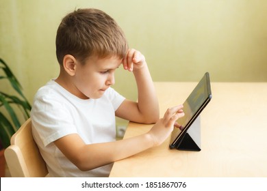 Cute schoolboy doing homework with computer at home. Child using gadgets for study. Education and distance learning concept. Homeschooling during quarantine. Stay at home entertainment. - Shutterstock ID 1851867076