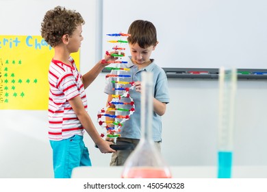 Cute schoolboys holding DNA model in classroom - Powered by Shutterstock