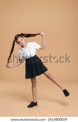 Cute schoolgirl on beige background, space for text