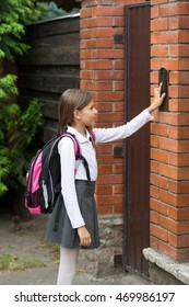 Cute Schoolgirl With Rucksack Ringing In Doorbell