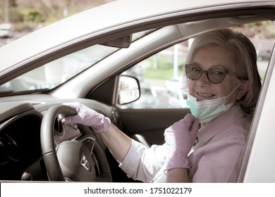 Cute Senior Woman With Protective Gloves Driving Silver Car Moves Away From Face Mask Against Coronavirus - New Normal Life Until End Of Pandemic