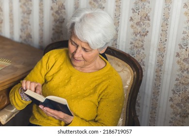 Cute Senior Woman Reading The Bible Medium Shot Living Room Religion And Spirituality Concept. High Quality Photo