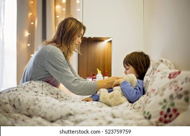 Cute Sick Child, Boy, Staying In Bed, Mom Giving Him Medicine And Checking For Fever