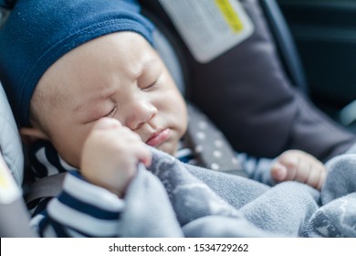 Cute Sleeping Baby In Child Car Seat Holding His Blanket Going For A Family Road Trip.