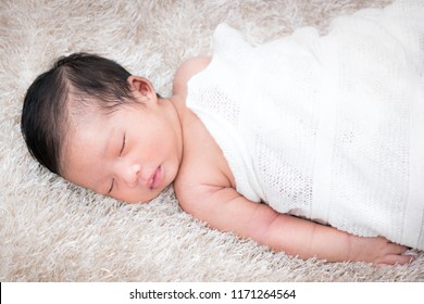 Cute sleeping newborn girl on a blanket.