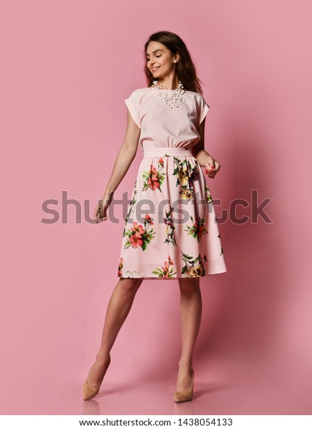デート用の美しいドレスを着たかわいいほっそりした女の子 ピンクの背景にスタジオでポーズを取るブラウスとフワフワの花のスカート 春と夏を迎えるワードローブの更新 の写真素材 今すぐ編集