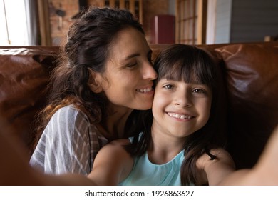 Cute Small 8s Hispanic Girl Child Have Fun With Young Mother Make Self-portrait Picture On Camera Together. Little Latino Kid Take Selfie On Cellphone With Mom, Enjoy Family Weekend At Home.