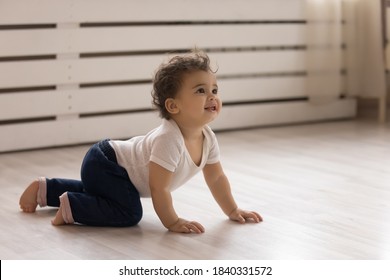 Cute small african American toddler baby child crawl on warm wooden home floor. Smiling little biracial infant kid play in children room indoors, explore world. Childcare, upbringing concept. - Shutterstock ID 1840331572
