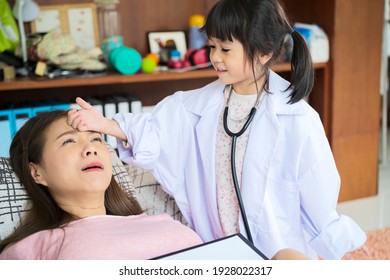 Cute Small Asian Girl As Doctor Play With Young Ethnic Mom Give Injection To Patient, Little Vietnamese Child Act Like Nurse Engaged In Funny Game With Mother Or Nanny At Home, Future Career Concept