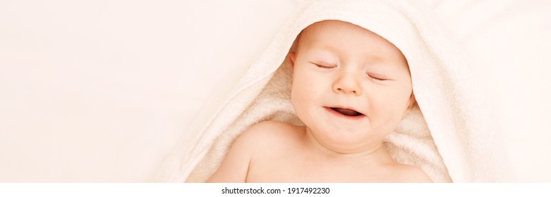 Cute small boy lying at bed. Childhood bath concept. Light background. Little child. Serious emotion. Copyspace. Stay home. Towel mockup. Closed eyes. Horizontal banner
