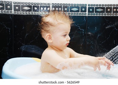 Cute small boy playing under shower