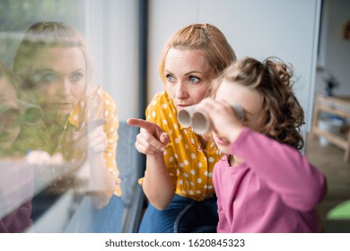 A cute small girl with mother indoors at home, playing.