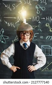 A cute smart boy in neat school uniform and glasses stands at the blackboard with chemical formulas with a strange invention on his head. Clever kids. Eureka. Educational concept.  - Shutterstock ID 2127777140
