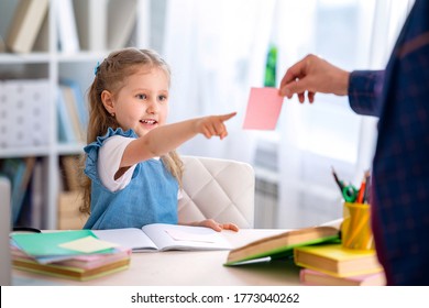 Cute smart little girl thinks about answer in the task. child is taught at home with a tutor . Home schooling. Dad helps you do your homework, learn a new topic. Making a decision child makes choice. - Powered by Shutterstock