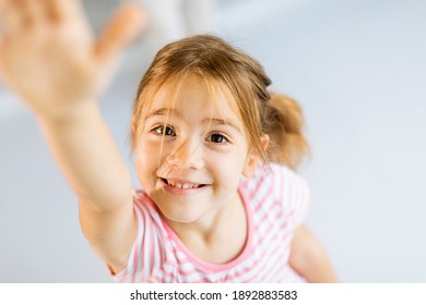 Cute Smiley Little Girl Rising Hand Towards Camera