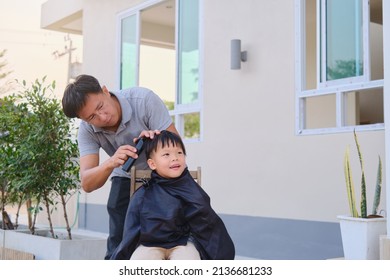 Cute smiling Asian kid young boy getting a haircut at home backyard, Father makes a haircut for his son during lockdown. Home haircut while in quarantine isolation during the Covid-19 health crisis - Shutterstock ID 2136681233