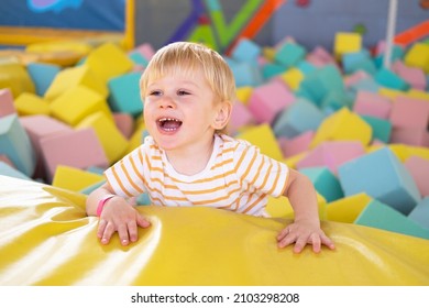 Cute Smiling Child Boy Plays With Soft Cubes In The Dry Pool In Play Center