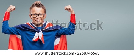 Cute smiling superhero showing off muscles, he is wearing a Union Jack flag as a cape