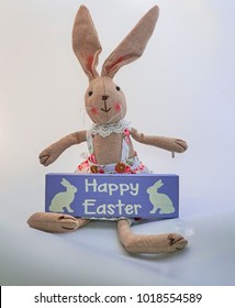                 Cute soft toy Easter bunny holding a happy Easter sign with white background               
