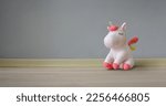 Cute soft unicorn plush toy on the floor. Close up shot, empty space