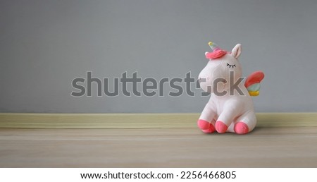 Cute soft unicorn plush toy on the floor. Close up shot, empty space
