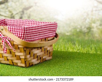 Cute Straw Picnic Basket On Green Grass Against The Backdrop Of Picturesque Summer Nature. Rest, Relaxation, Day Off. There Are No People In The Photo. There Is Free Space To Insert.