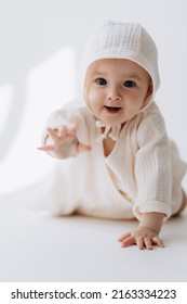 Cute studio portrait of a little newborn which has already begun to crawl. The child laughs and rejoices in his first little steps - Shutterstock ID 2163334223
