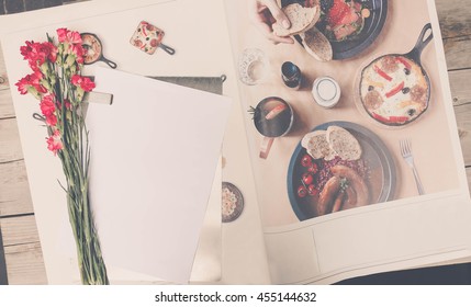 Cute stuff (nut red carnation flower, paper on the stainless tray and mobile phone) on wooden background.craft mock up set with vintage effect and low light. 